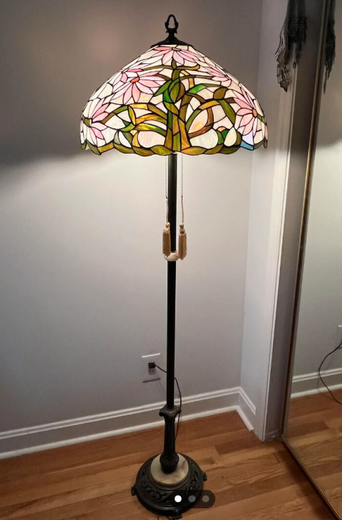 Thrifted stained glass floor lamp with floral design on wooden floor.
