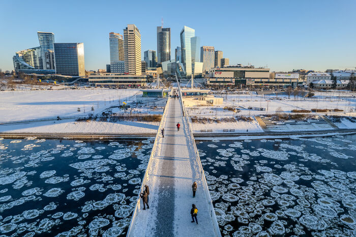 Bird’s-eye view of a snow-covered bridge and skyline in Lithuania.