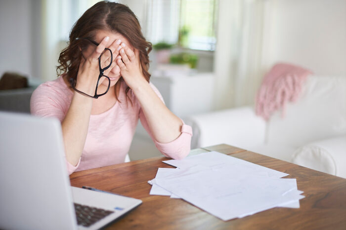Woman stressed at work desk, illustrating American norms.