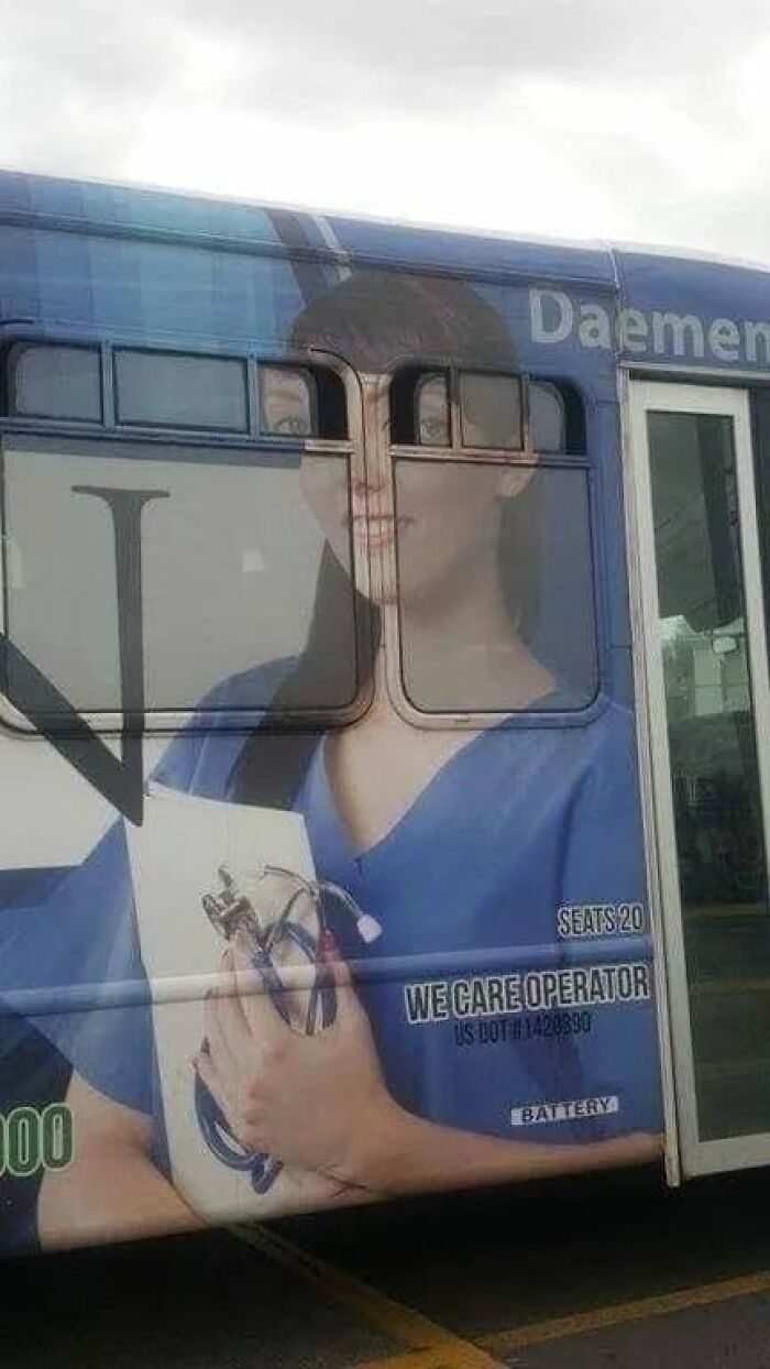 Weird image of a bus ad with misaligned windows creating a humorous face distortion effect.