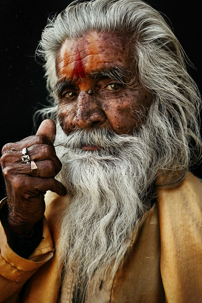Captivating expressive face of an elderly man with a long white beard and traditional clothing.