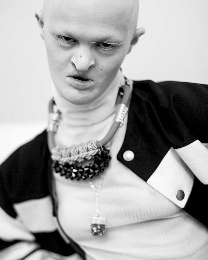 Unique model in a striking black and white outfit, featuring bold accessories and a confident expression.