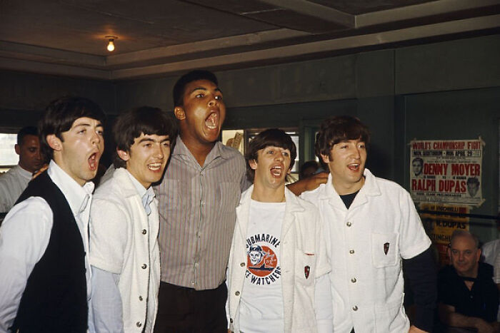 Five people in a room, joyfully posing and laughing, capturing true happiness.