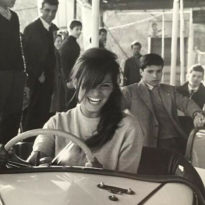 Woman laughing while driving a bumper car, capturing true happiness.