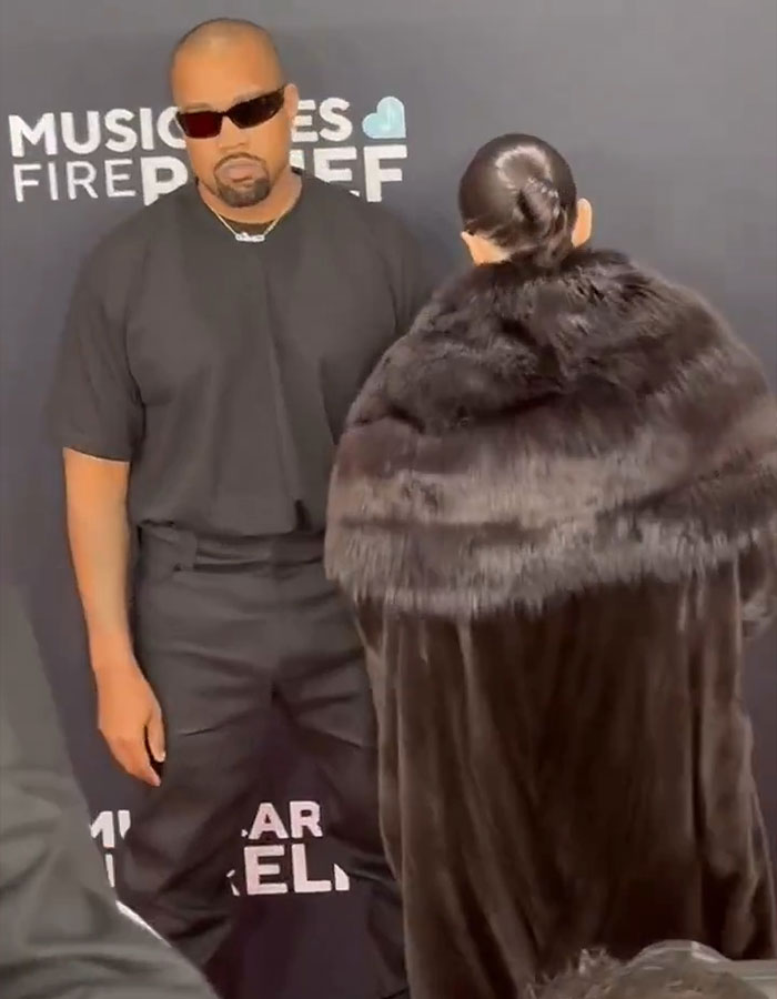 Man in sunglasses beside a woman wrapped in a fur coat at a formal event. Man in sunglasses beside a woman wrapped in a fur coat at a formal event.