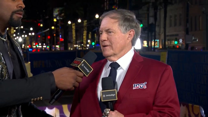 Person in a red blazer being interviewed on a lively street, holding a microphone, related to Snoop Dogg's viral age gap joke.