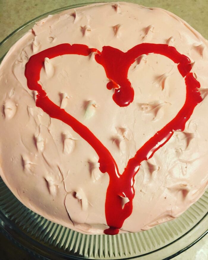 Pink cake with a red heart icing design, poorly executed, symbolizing a Valentine's Day fail.