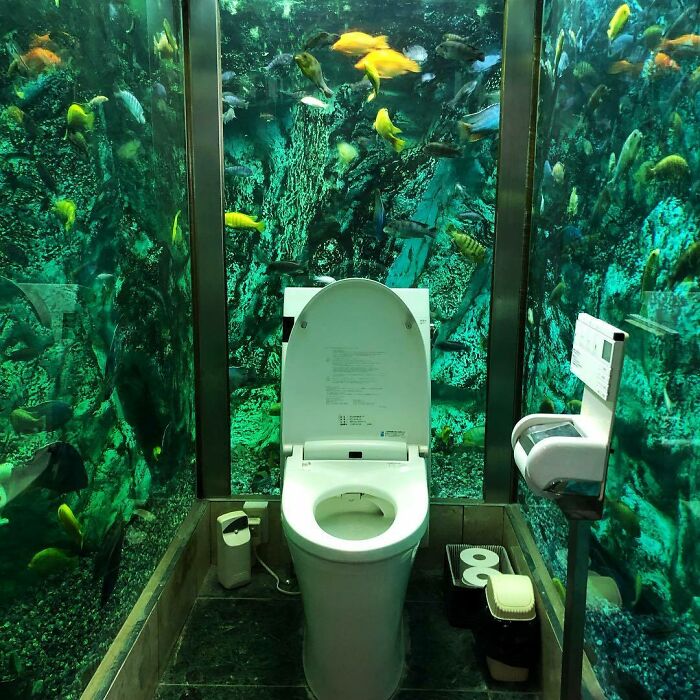 Aquarium-themed bathroom in Japan with fish swimming around the toilet.