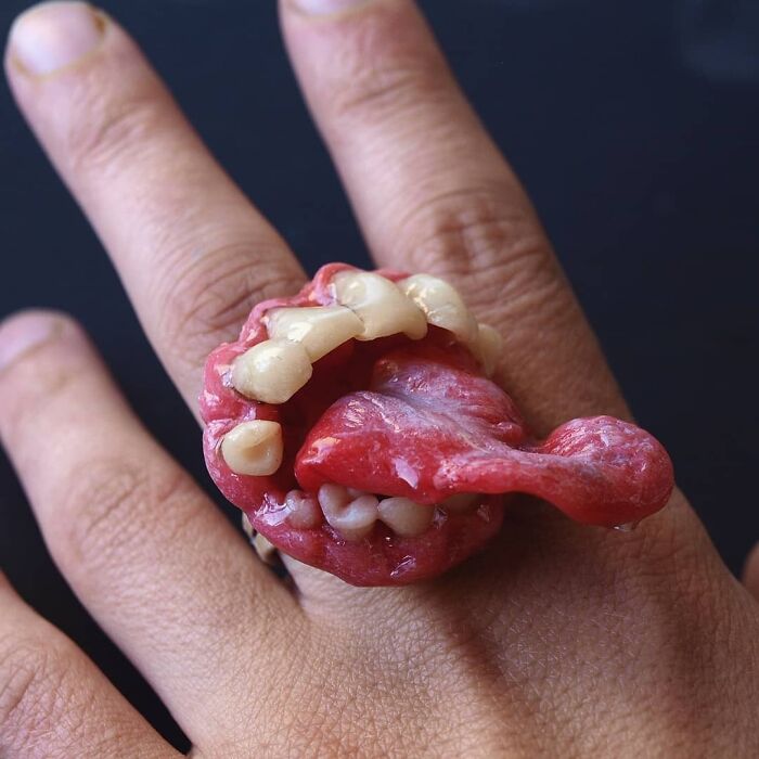 Creepy handmade ring featuring a detailed mouth and tongue design worn on a person's finger.