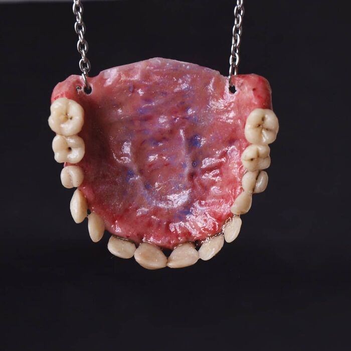 Creepy handmade crafts necklace resembling realistic teeth and gums.