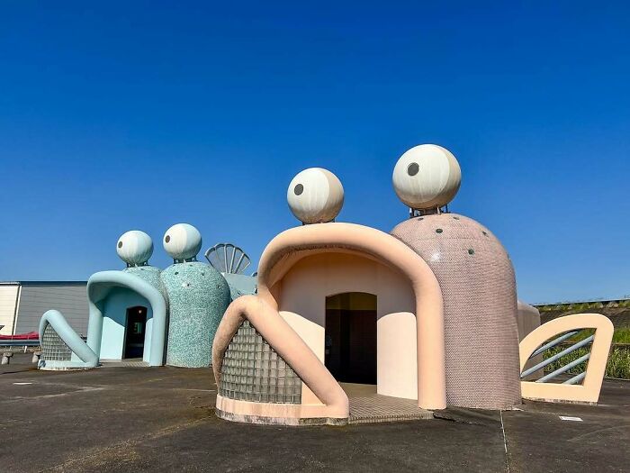 Whimsical building shaped like a frog in Japan under a clear blue sky.
