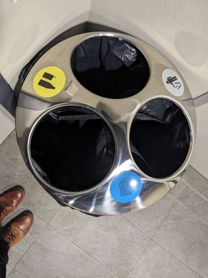 Recycling design fail with confusing labels on a three-section waste bin.