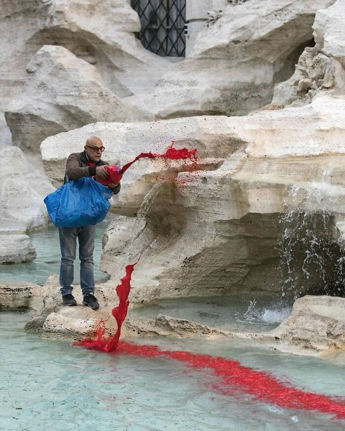 Person pouring red liquid into a fountain, illustrating strange internet trends.