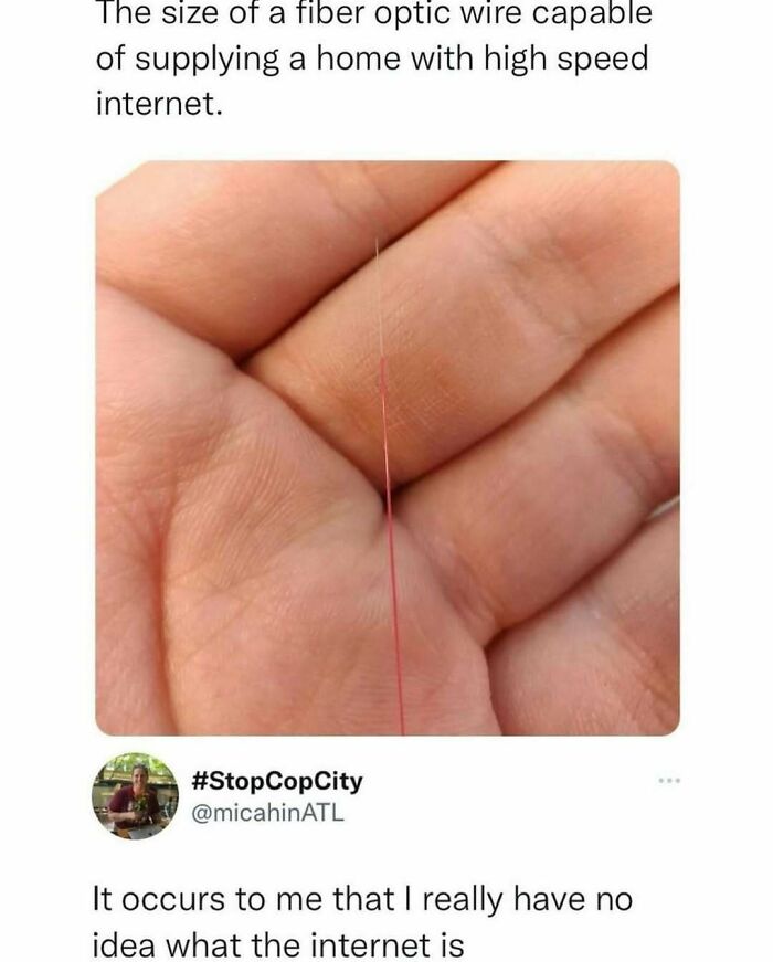 Close-up of a hand holding a thin fiber optic wire, highlighting random memes humor with text about internet size confusion.