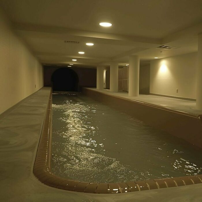Dimly lit indoor pool resembling liminal spaces, creating an eerie atmosphere.