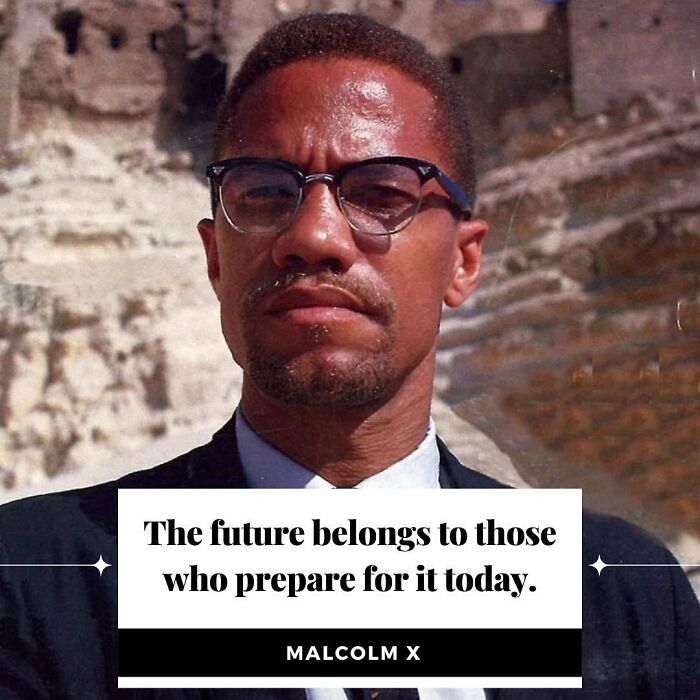 Man wearing glasses in front of rocky background with anti-capitalism quote: "The future belongs to those who prepare for it today."