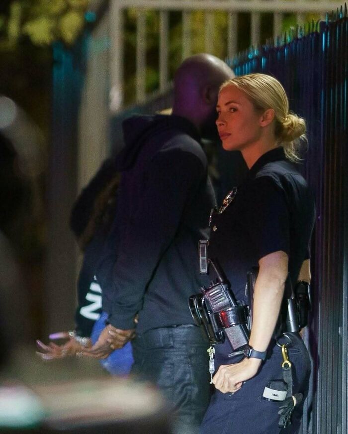 Police officer with a detained individual at night, showcasing the strange nature of internet-shared images.