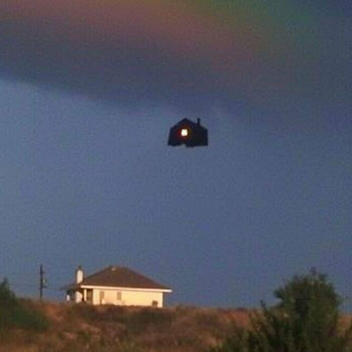 A floating house under rainbow skies, representing eerie liminal spaces.