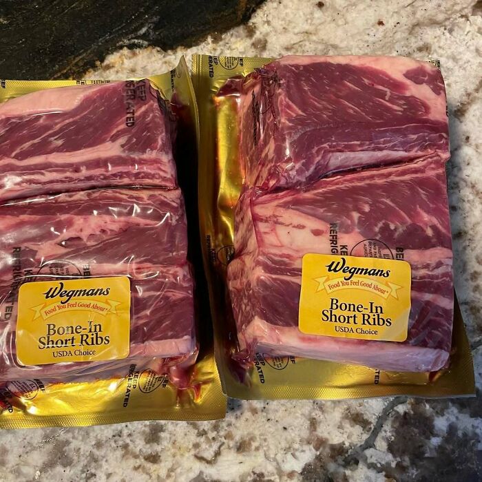 Packaged bone-in short ribs from Wegmans on a marble countertop, perfect for those who love to cook.