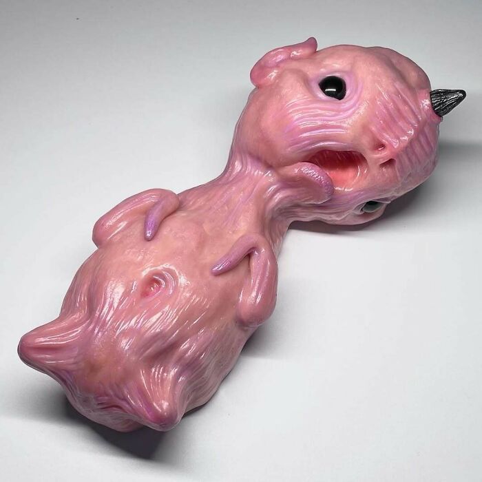 Creepy handmade craft depicting a unique pink creature with textured skin and a small horn.