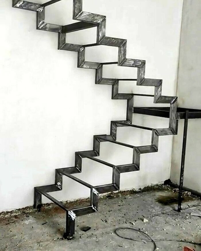 Unusual metal staircase design showcasing architecture fails with a zigzag pattern against a white wall.