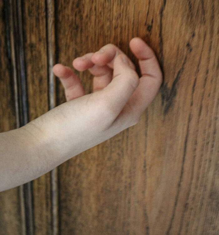 Hand knocking on wood, illustrating superstitions like "knock on wood" in a text screenshot highlighting common beliefs.