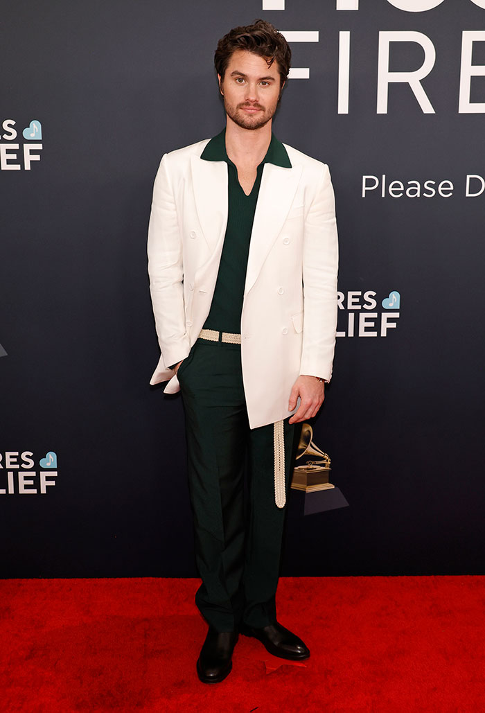 Man in white blazer and dark pants on Grammy Awards red carpet.