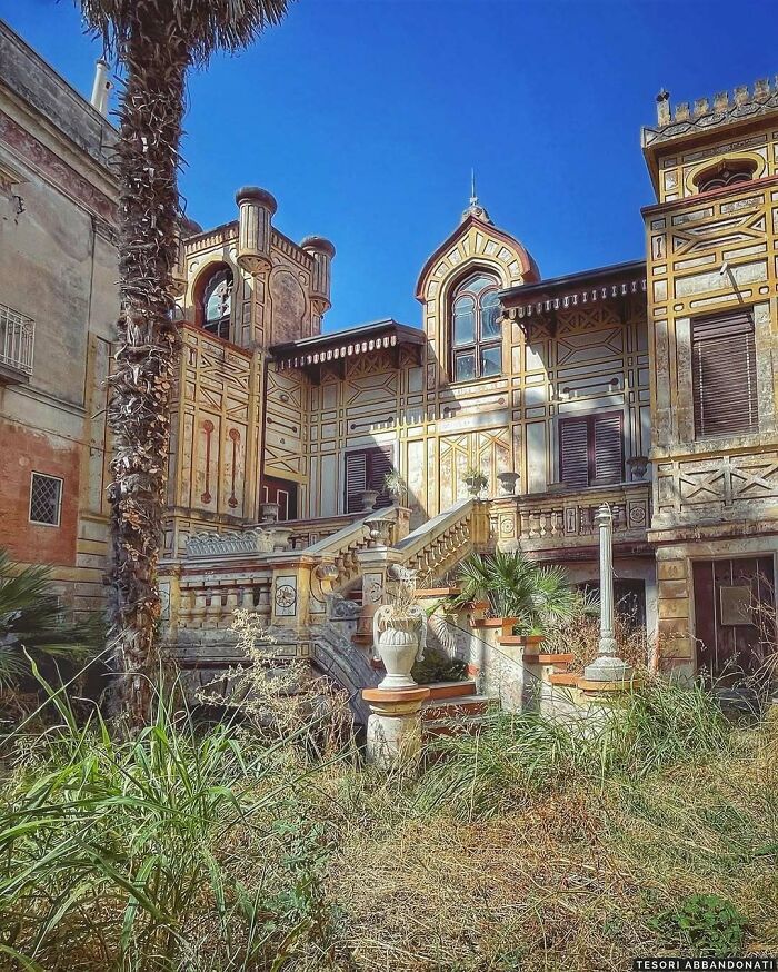 Historic villa with overgrown plants, showcasing nature reclaiming civilization.