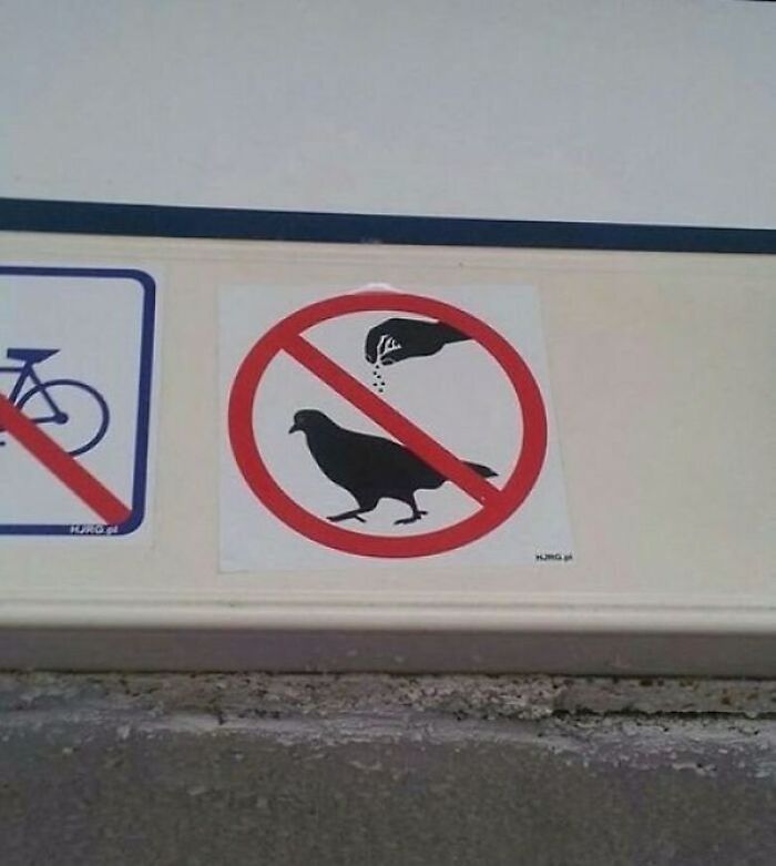Prohibition sign design fail with a hand feeding a bird.