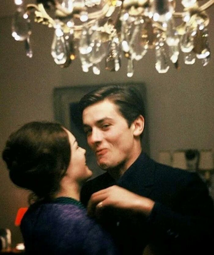 A couple laughing under a chandelier, capturing true happiness together indoors.