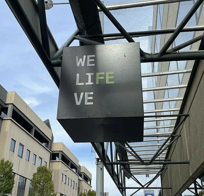 Sign on a building with text aligned vertically as "WE LI FE VE," illustrating a design fail.