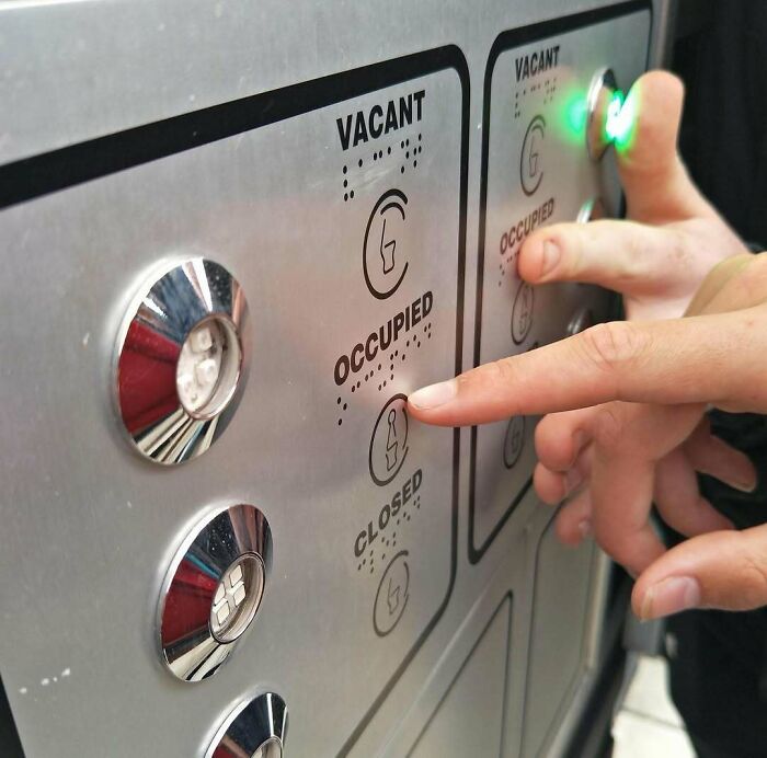 Fingers pointing at a confusing elevator panel with incorrect options, illustrating design fails.