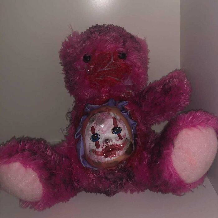 Creepy handmade craft featuring a pink teddy bear with a sinister clown face in its chest.