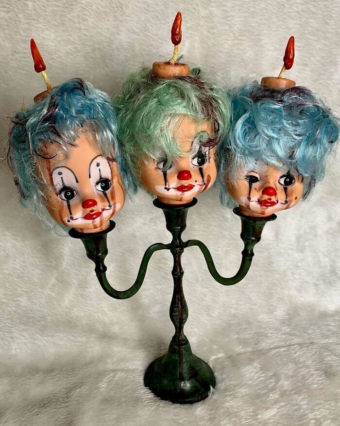 Creepy handmade crafts: a candelabra with three clown doll heads as candles.