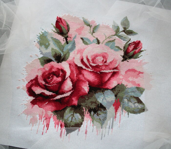 Cross stitch pattern with pink and red roses, featuring detailed leaves and buds.