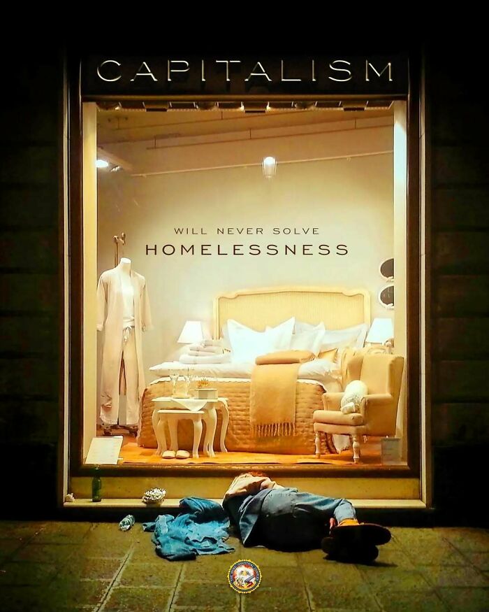 Storefront displaying luxury bedroom decor with "Capitalism will never solve homelessness" text, highlighting anti-capitalism sentiment.