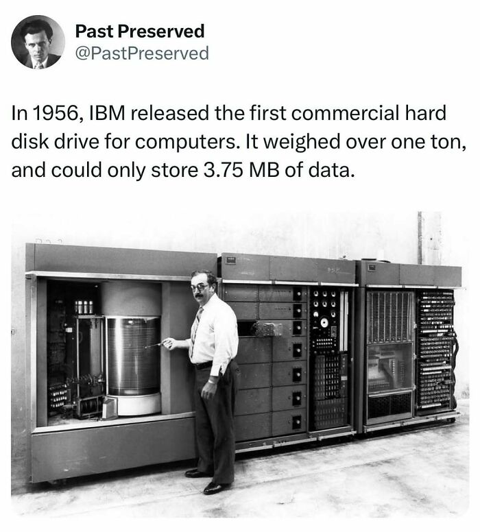Man standing next to the 1956 IBM hard disk drive, a historical artifact that stored 3.75 MB, highlighting technological evolution.