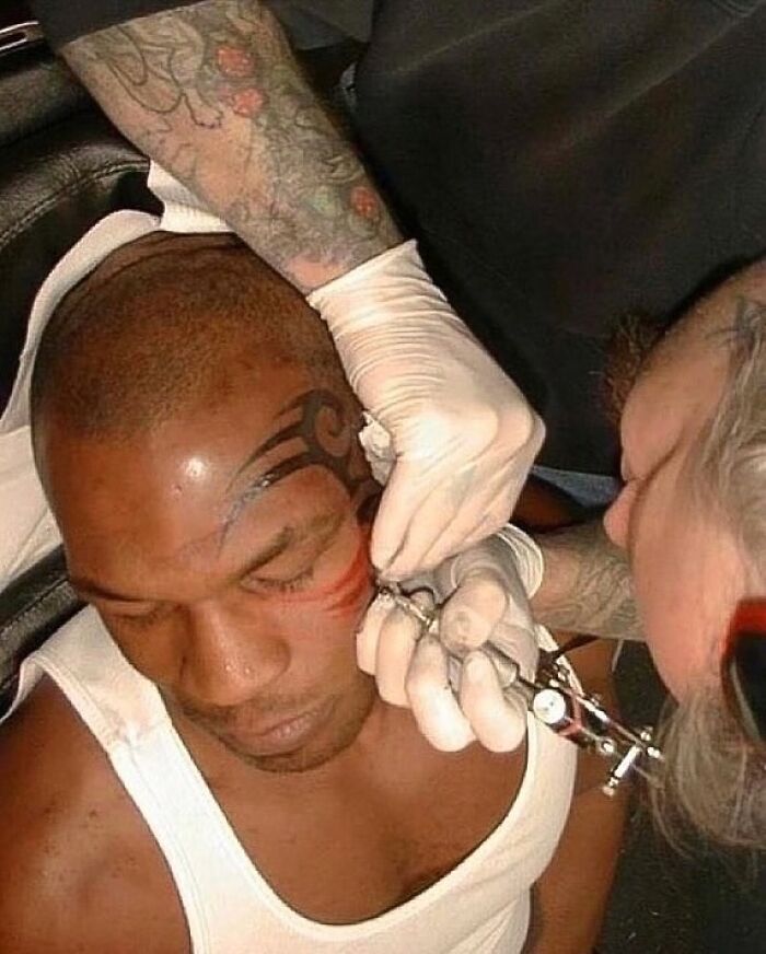 Person getting a face tattoo while seated, showcasing one of the strange aspects of the internet.