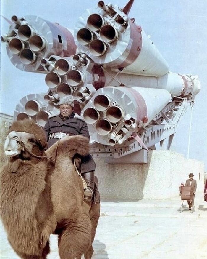 Un hombre posa para una foto montado en un camello frente a un cohete Soyuz en Baikonur, Kazajstán, en la década de 1980.