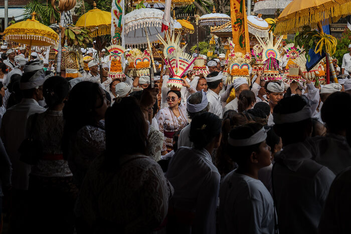 Balinese people celebrating Galungan with traditional attire and ornate offerings in a vibrant procession.