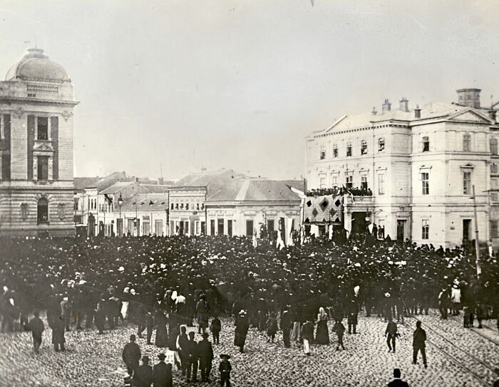 Historical crowd gathering in a city square, illustrating surprising war victories in an early 20th-century setting.