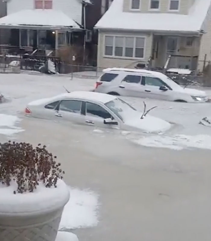 Detroit neighborhood street and cars covered in ice after a water main bursts.