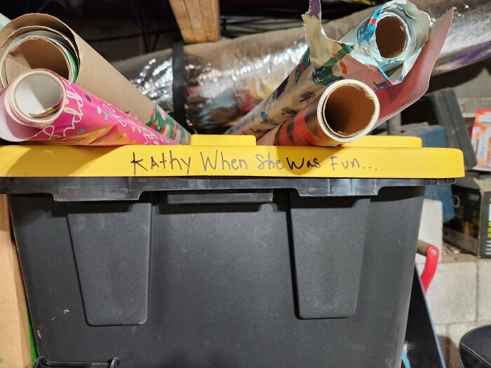 Box labeled humorously, possibly by annoying boyfriends or husbands, containing colorful wrapping paper rolls.
