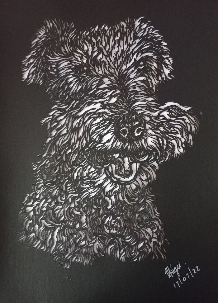 Intricate paper artwork depicting a dog, hand-cut with a scalpel from a single sheet.