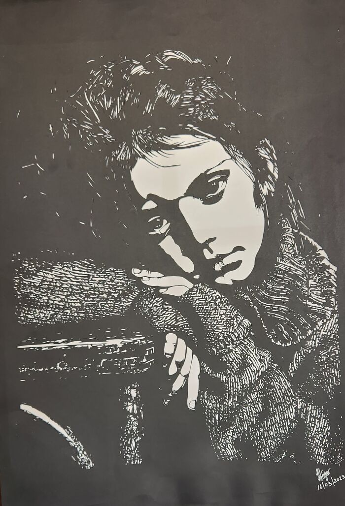 Paper artwork depicting a thoughtful person, intricately hand-cut with a scalpel from a single piece of paper.