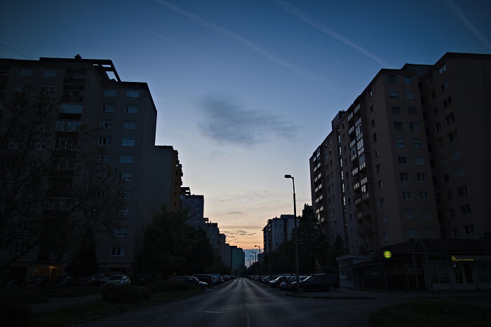 Hungarian panel buildings at dusk, silhouetted against a darkening sky, illustrating urban architecture.