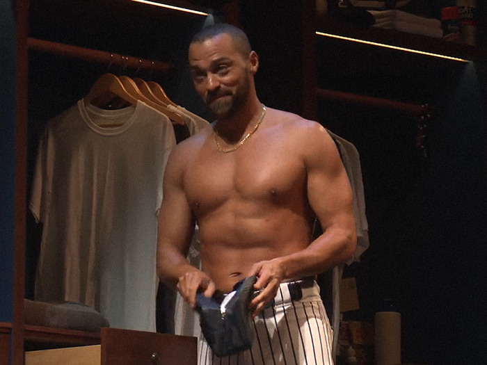 Jesse Williams in a dimly lit room, shirtless, holding clothing, showcasing refusal of prosthetics.