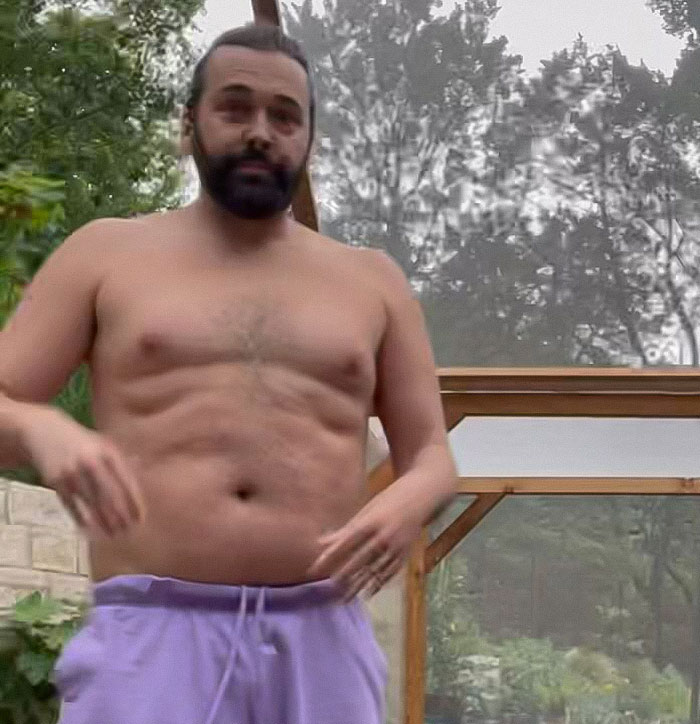 Person in a greenhouse setting showcasing a weight loss transformation, wearing purple shorts.