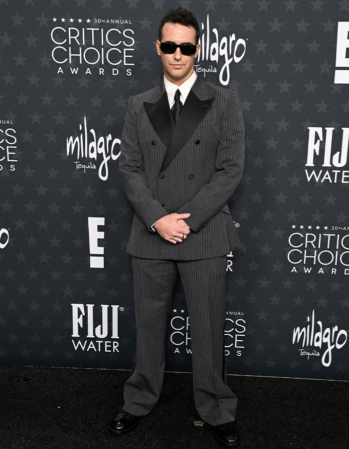 Man in a pinstripe suit and sunglasses at the Critics Choice Awards red carpet.