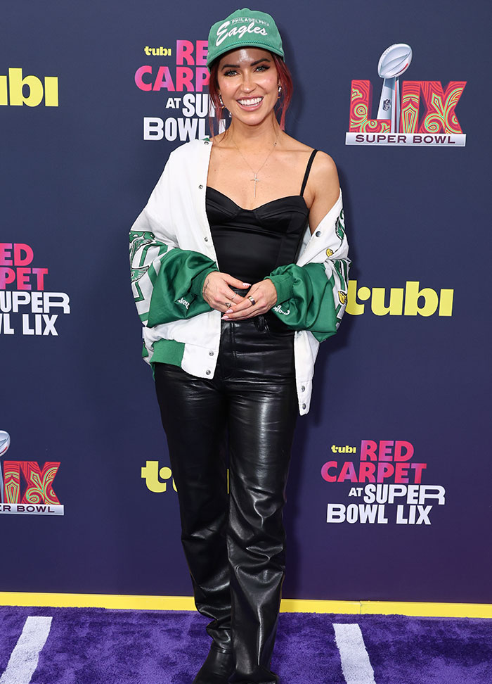 Person in a Philadelphia Eagles outfit at the Super Bowl 2025 red carpet, featuring head-turning fashion.